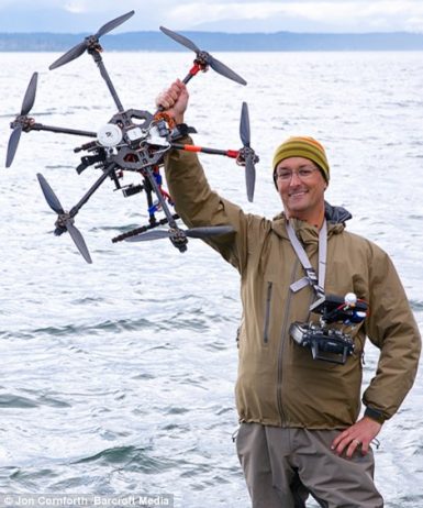 Photographer Jon Cornforth holding up and operating his remote controlled hexacopter which he used to take the snaps of Hawaii