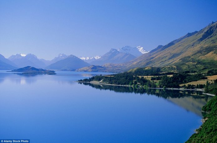 The still Lake Wakatipu at Glenorchy appears to merge into the blue-hued Mount Earnslaw behind