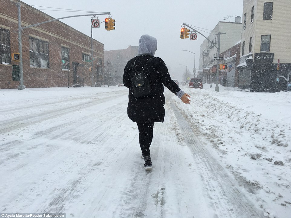 A woman strolls through New York City streets after the roads were closed to vehicles on Saturday afternoon during Storm Jonas