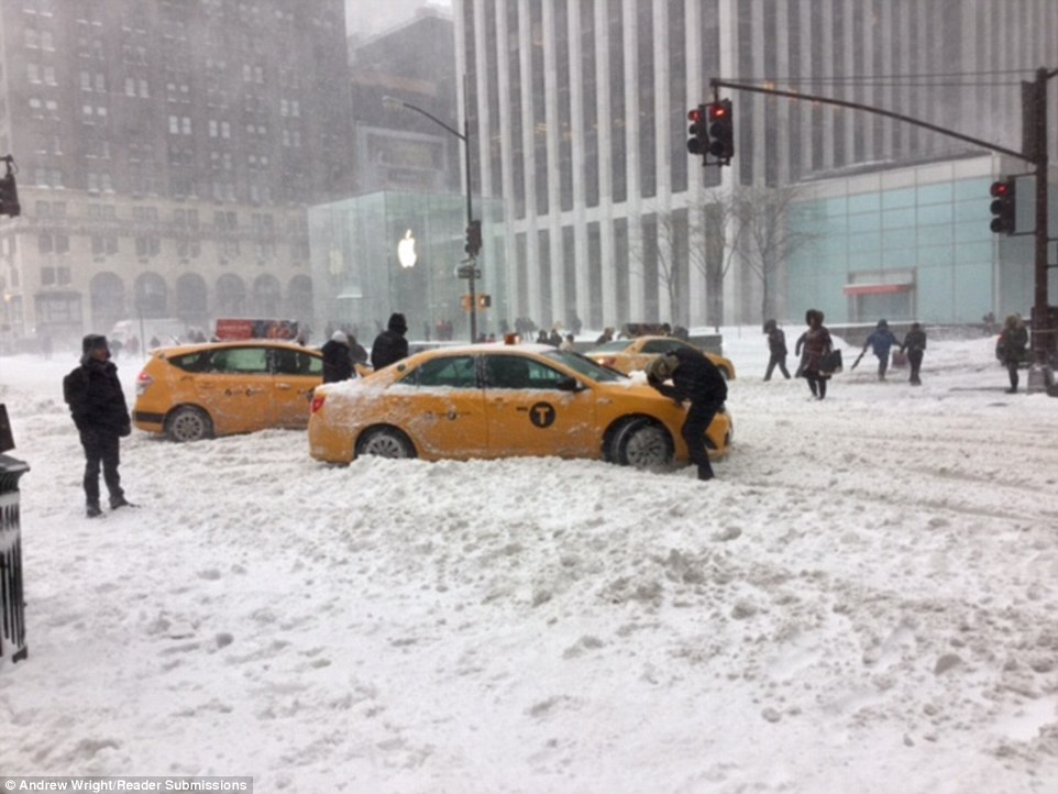Cab drivers work to remove their cars on Fifth Avenue in New York City after snow covered the streets, making it difficult to drive