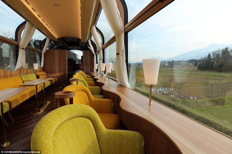 The train features armchair-style seating that faces out towards the mountains nearby