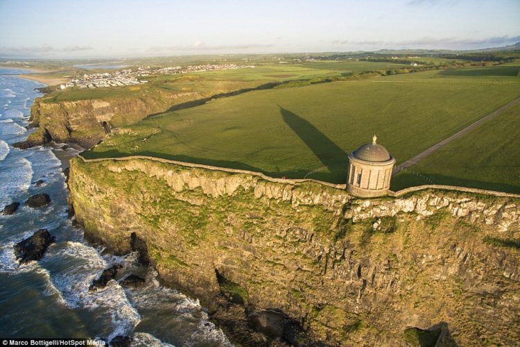 As the evening hours close in the light softens and the shadows of The Mussenden Temple in County Londonderry (above), Northern Ireland, lengthen