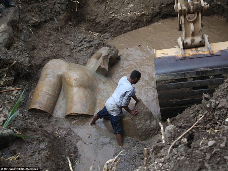 Archaeologists from Egypt and Germany have found a massive 26ft (8 metre) statue submerged in ground water in a Cairo slum