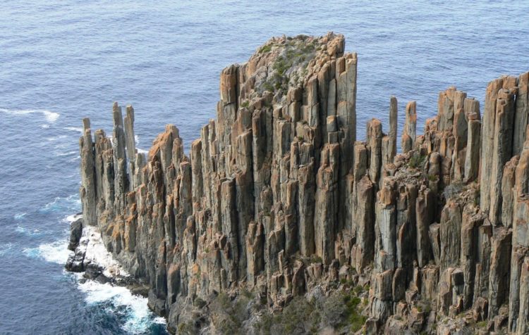The doleritic clifts surpass 100 m in topography above the sea along much of the southern and eastern coast of Tasmania, and some singular columns occur as giant “totem poles” standing in the sea.