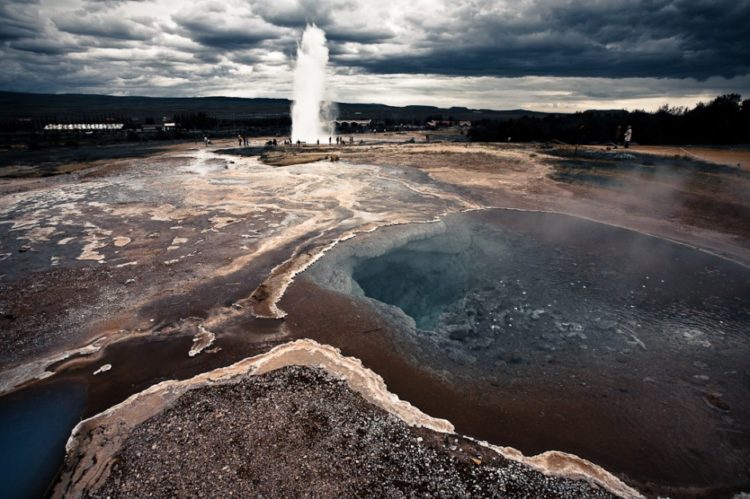 Most geysers are found in highly silicic rhyolitic rocks. Superheated waters dissolve silica from these rocks at temperatures of around 300'C which exist in the high-pressure environment deep under the surface. 