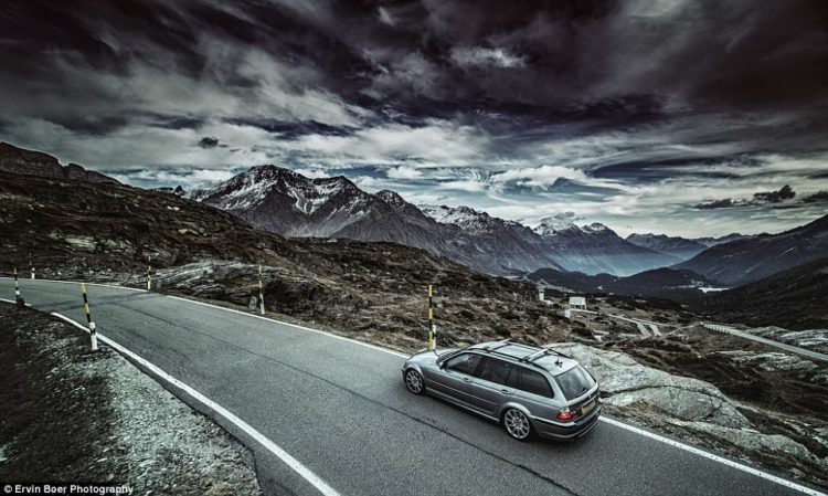 Dark clouds loom over one of the luxury cars on the winding road up to the Stelvio Pass, a mountainous road in the Italian Alps