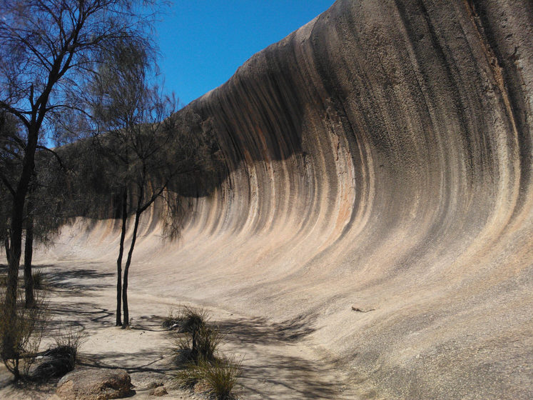The shape of the rock is not caused by a wave phenomenon, rather its rounded wave-like shape was formed by subsurface chemical weatheringsubsurface chemical weathering 
