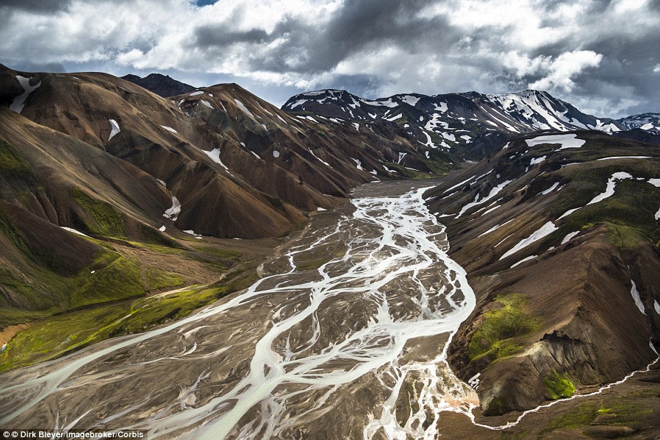 The spectacular Joekulgilkvísl snakes its way through the Icelandic Highlands. The Rhyolite Mountains can be seen behind partially covered with snow