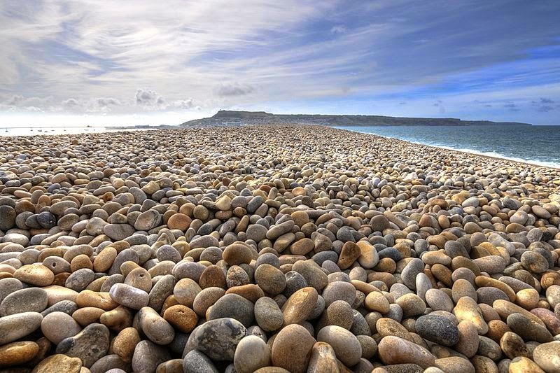 The English Chesil Beach “Chesil Bank”lies in the county of Dorset. It is popular for its pebbles stretched 18 miles (28 kilometers) long and north-west from Portland to West Bay.