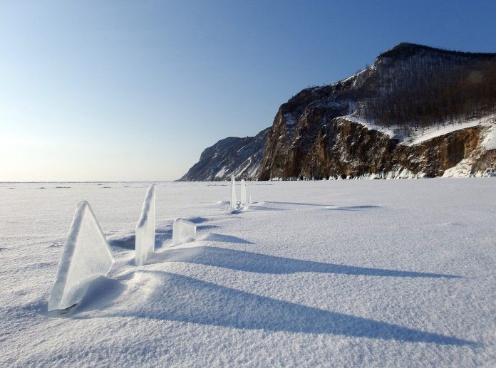 The vast, frozen lake is surrounded by mountains; the Baikal Mountains on its northern shore and Barguzin Range stretching northeast.