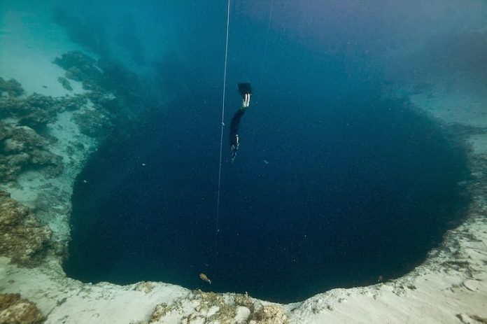 An underwater sinkhole is known as a blue hole in geology.  There is a blue hole named Dean's Blue Hole on Long Island, Bahamas.