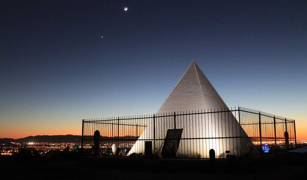 The small Hunt's Tomb is a white pyramid that is surrounded by an enclosure at the highest point of a hill inside Papago Park.