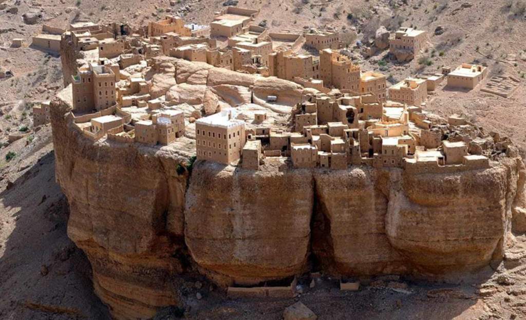 The village's mud-brick structures are perched atop a massive boulder that provides a view over the Wadi Dawan valley.